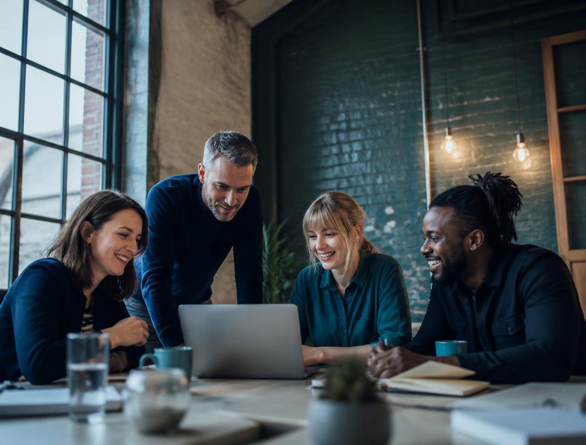 A small regional business team working together in a converted warehouse office